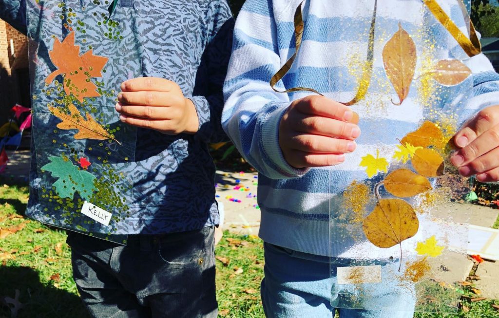 Close up of two children's hands holding homemade suncatchers