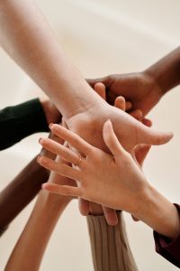 About six hands outstretched and overlayed on one antoher